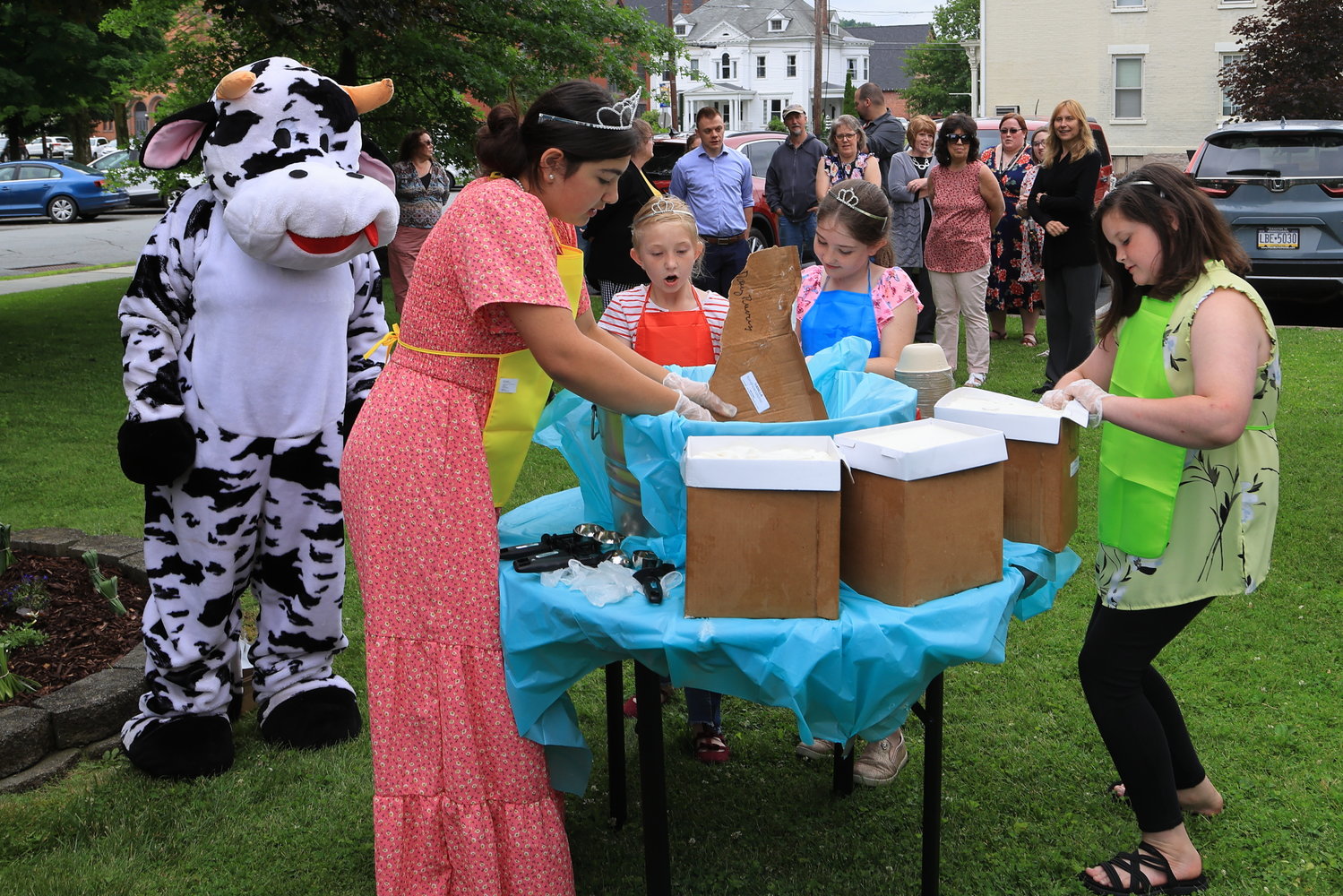 An Ice Cream Sundae building competition between the Wayne County Dairy Princess team and the Wayne County Commissioners was held on the lawn of the Wayne County Court House following the regular June 16, Commissioners meeting. Around the table are  2022 Wayne County Dairy Princess Elektra Kehagias, left, getting the ice cream into the big tub with the help of Dairy Miss Chloe Tyler, Dairy Miss Zoe Tyler and Dairy Miss Kenley Roberts.